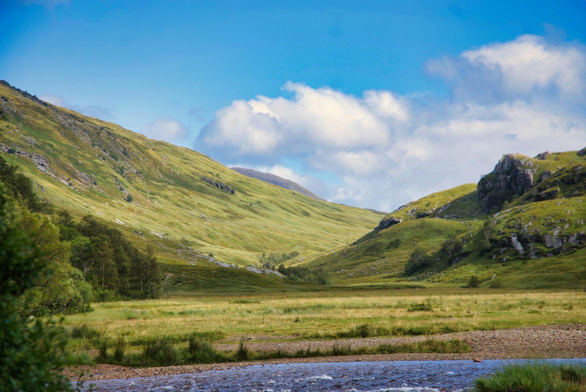 A green Scottish glen under a soft cloudy sky